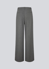 Grey suit pants with pleats and wide legs. Tuesdaymd pants have a medium-highwaist, zipper, side pockets and paspoil pockets in the back. The model is 175 cm and wears a size s/36.