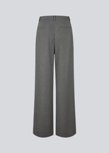 Grey suit pants with pleats and wide legs. Tuesdaymd pants have a medium-highwaist, zipper, side pockets and paspoil pockets in the back. The model is 175 cm and wears a size s/36.