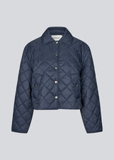 Short navy quilted jacket in 100% recycled nylon. The Uffemd jacket has a light, casual look with a shirt collar, press buttons, and practical side pockets – an ideal layer for the transitional seasons. The model is 175 cm and wears a size S/36.
Material:
100% Recycled nylon
Lining:
100% Polyester
Filling:
100% Polyester