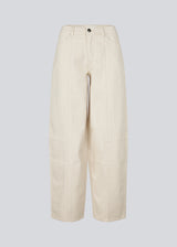 Beige barrel jeans with stitching details. The UnikaMD Jeans feature a relaxed fit with belt loops, a concealed zip fastening, a button, and classic front and back pockets – a cool take on everyday denim. 