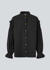 Feminine black shirt with smock and ruffle details. The UlfurMD Shirt features tonal stripes, a collar, button closure, and voluminous sleeves with smock and ruffles – an elegant and modern shirt that adds a sophisticated touch to both everyday and work looks. The model is 175 cm and wears a size S/36.
Material:
40% Cotton
60% Recycled Polyester