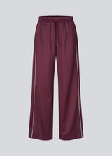 Dark red tracksuitpants with wide legs in 100% recycled polyester. Utopiamd pants has sidepockets, logo and an elastic waistband with tiebands.