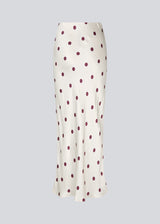 Long white satin skirt with polka dots. The Vanjamd Print Skirt features a loose, elegant drape and an elastic waistband for a comfortable and feminine look. Perfect for both everyday and evening outfits.