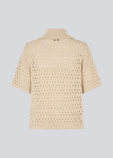 Elegant and lightweight cardigan in beige in a beautifully knitted openwork pattern. The VesterMD cardigan features short sleeves, a collar, and an adjustable drawstring closure at the front, creating a feminine and relaxed look. Made from 100% organic cotton for soft and breathable comfort.