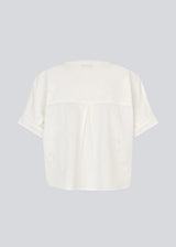 Short-sleeved shirt-blouse with a solid-color print. The VilleminMD shirt features a button closure, round neckline, and rolled-up sleeves, with a length that reaches the waistband. A timeless and elegant choice that can easily be styled for both everyday and evening wear.