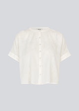 Short-sleeved shirt-blouse with a solid-color print. The VilleminMD shirt features a button closure, round neckline, and rolled-up sleeves, with a length that reaches the waistband. A timeless and elegant choice that can easily be styled for both everyday and evening wear.