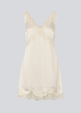 Short satin dress in white/cream with lace details. Vuemd dress features wide straps, a crossed detail at the bust, and a hidden side zip. Elegant and feminine – ideal for both everyday wear and special occasions.