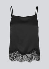 Delicate satin top in black with lace details on the bottom. Vuemd top has adjustable straps and refined lace details at the hem. Perfect worn alone or styled as part of a layered look.