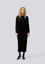 Black long wide satin skirt. Parveenmd skirt has an elastic waistband. The model is 175 cm and wears a size s/36.