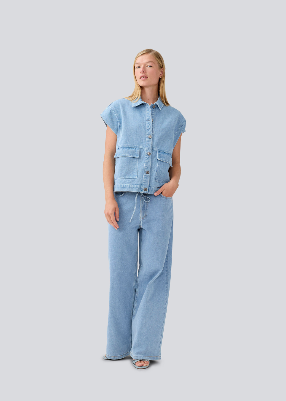 Vest with a loose fit and dropped shoulders in denim. TenorMD vest has two pockets, shirt collar and a button closure in front.
