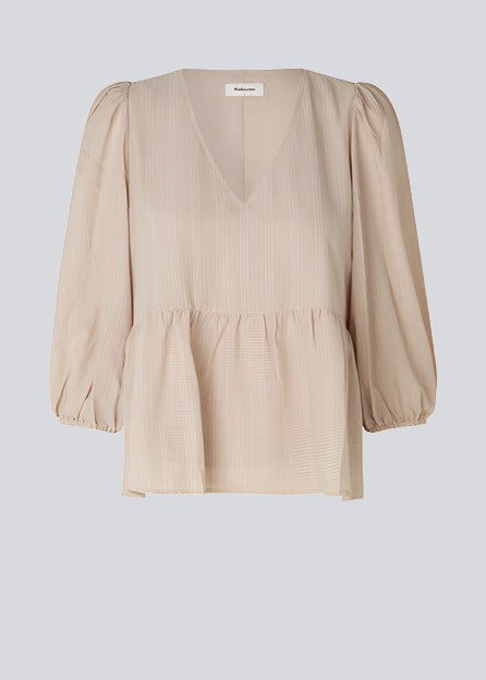 Top in beige in a loose silhouette with 3/4 length sleeves, v-shaped neckline and a cutline at the waist for ekstra volume on the bottom of the top.