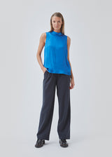 Sleeveless top in blue with a loose fit with a high neck and a small opening with button closure at the back. BeateMD top is crafted from a more resposible, softly draping satin.
