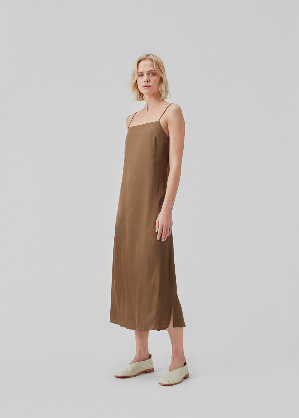 Slip in dress in satin with an A-shape and classic expression. CarwynMD dress has adjustable spaghetti straps and a straight neckline in front and back. The model is 177 cm and wears a size S/36.