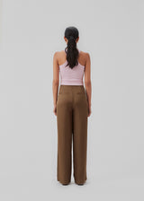 Satin pants in a classic look. CarwynMD pants are designed with wide legs, pleats in front, and hidden closure with zip fly and clasp. The model is 174 cm and wears a size S/36.