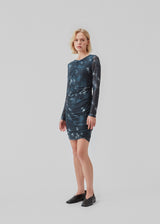 Short dress with draped details and multiple layers. CliffordMD print dress has a round neck and long sleeves in mesh.  The model is 177 cm and wears a size S/36.