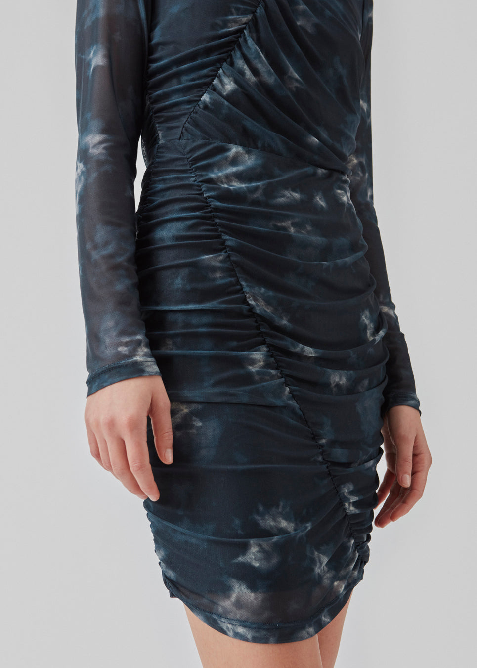 Short dress with draped details and multiple layers. CliffordMD print dress has a round neck and long sleeves in mesh.  The model is 177 cm and wears a size S/36.