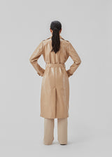 Coat in a shiny material. CollinsMD coat has a classic trenchcoat look with wide collar and lapel, button closure, and belt at the waist.