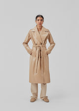 Coat in a shiny material. CollinsMD coat has a classic trenchcoat look with wide collar and lapel, button closure, and belt at the waist.