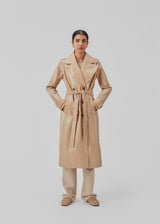 Coat in a shiny material. CollinsMD coat has a classic trenchcoat look with wide collar and lapel, button closure, and belt at the waist.
