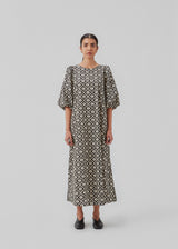 Long dress with a wide skirt and voluminous puff sleeves. CoraMD print dress has a round neck with a cut out and bow in the back. Made from organic cotton.  The model is 174 cm and wears a size S/36.