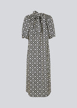 Long dress with a wide skirt and voluminous puff sleeves. CoraMD print dress has a round neck with a cut out and bow in the back. Made from organic cotton.  The model is 174 cm and wears a size S/36.