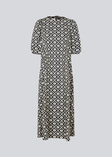 Long dress with a wide skirt and voluminous puff sleeves. CoraMD print dress has a round neck with a cut out and bow in the back. Made from organic cotton.  The model is 174 cm and wears a size S/36.