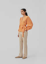 Wrap top with puff sleeves and floral print in EcoVero viscose. CorinnaMD print top has a deep v-neck and a wide tie-belt at the waist.  The model is 177 cm and wears a size S/36.