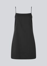 Short dress in black with a clean look in woven cotton. CydneyMD dress is slightly tailored, has adjustable straps, and a hidden zipper on one side. The model is 174 cm and wears a size S/36.