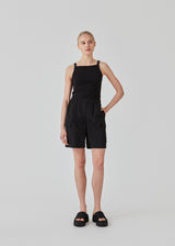 Tight fit basic black top with a high and straight neckline. DaeMD top is made from a rib-knitted organic cotton. The model is 177 cm and wears a size S/36.