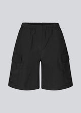 Cargo shorts in black in nylon with wide legs. DilaraMD shorts have an elasticated waistband and two large patch pockets on the sides. The model is 177 cm and wears a size S/36.