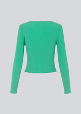 Slim fitted, slightly cropped cardigan in green with buttons at the front. DorisMD cardigan has a deep and round neckline, long sleeves, and lettuce hems. The model is 177 cm and wears a size S/36.