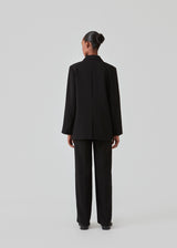 Gale blazer in Black has a classic and elegant design, fulfilled by the beautiful revers collar and a long fit. The blazer has a button closure at the front and a chest pocket at the left side. Buy Gale Pants, Gale straight pants, GaleMD skirt or GaleMD shorts in the same color that fits the Blazer.  The model is 177 cm and wears a size S/36.  This blazer has a spacious fit. We recommend sizing down.