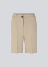 GaleMD shorts in beige have a classic design. The shorts cuts at knee-length, and have wide legs with creases for an elegant look. The model is 173 cm and wears a size S/36.  Buy Gale blazer in the same color that fits the shorts.