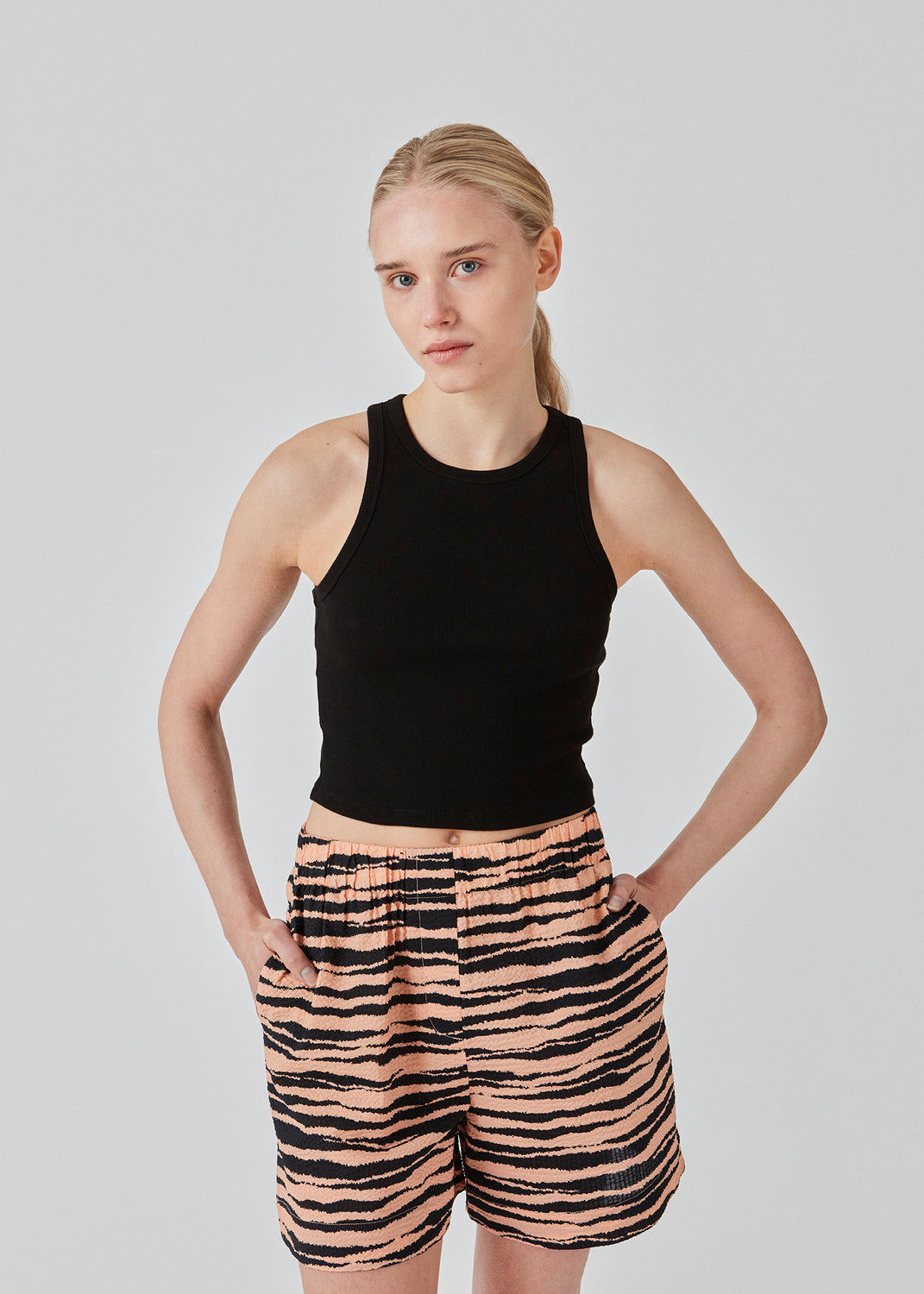 Basic top cut from a soft ribbed jersey fabric. IgorMD crop top in the color Black is styles with a slim fit and cropped fit with racer-shaped back. Perfect for a sporty look. The model is 173 cm and wears a size S/36