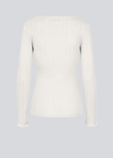 Tight fitted longsleeved t-shirt with a feminine lettuce trim on the sleeves. Issy LS t-shirt in color Off White is made from a soft jersey quality with a decorative drop needle pattern.