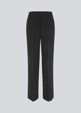 Classic pants with pressfolds and straight legs. Nelli pants are closes by an hidden zipper at the side with an elastic waistband for a more comfortable fit. The model is 173 cm and wears a size S/36