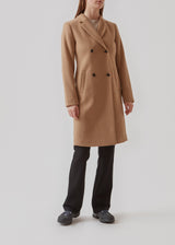 Beautiful, knee-length wool coat in light brown. Odelia coat is closed at front by 4 buttons and is fitted around the waist, which gives a feminine look. Because of the high content of wool the jacket will be perfect for fall and the mild winters.