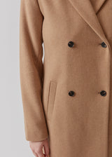 Beautiful, knee-length wool coat in light brown. Odelia coat is closed at front by 4 buttons and is fitted around the waist, which gives a feminine look. Because of the high content of wool the jacket will be perfect for fall and the mild winters.