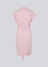 Panne dress is a cotton dress in the color dusty sorbet with a beautiful silhouette. The dress features a nice collar, tie band, and a sleeveless design with wide shoulders. The model is 173 cm and wears a size S/36.