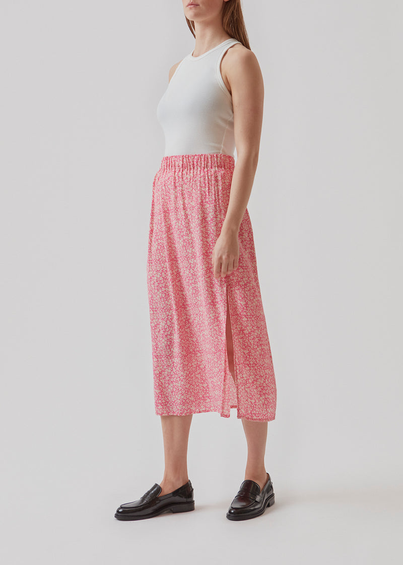 Airy, long skirt in pink print. The skirt has elastic at the waist and a slit at the side. Use the skirt, RinnaMD print skirt for everyday or party.  Buy matching RinnaMD print top in the same color and print.