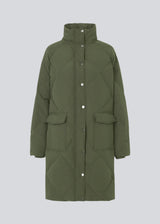 Quilted jacket with down filling i green. ScarlettMD jacket is knee length with a high stand-up collar and a zipper with wind flap with press-studs. The jacket has two patch pockets with press studs in front and an elasticated cuff. The model is 177 cm and wears a size S/36.