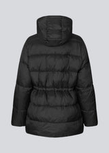 Puffer jacket in black with an oversized silhouette and adjustable drawstring waist. StellaMD jacket is designed with a high-standing collar, hood, two-way zipper and paspel pockets.
