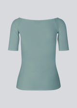 Tansy top in the color stormy sea has a simple look with a wide neckline at front and back and narrow sleeves. The top is slim fit without being tight. The model is 174 cm and wears a size S/36