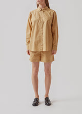 Shorts in a light, organic cotton poplin. TapirMD shorts have a high waist with elasticated waistband and short, wide legs. Pockets at side seam and a short slit at sides.  Material: 100% Organic Cotton
