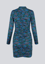 Short dress in the color Malibu Poerty Flower, with long sleeves and low collar. TilloMD print dress is designed with a slim shape with a wrinkled, elastic detail down the center front and center back.