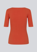 Tight fit top in red in a ribbed cotton jersey with a deep neckline in front and short sleeves cutting just above the elbow. The model is 175 cm and wears a size S/36.