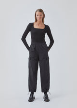 Cargo pants in nylon with elastic waistline and adjustable hems with elastic drawstrings. TrentMD pants have patch pockets on the legs. In black.  This is the same model as our popular pants AmayaMD pants. Just in a thicker material, perfect for fall and winter.