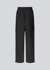 Cargo pants in nylon with elastic waistline and adjustable hems with elastic drawstrings. TrentMD pants have patch pockets on the legs. In black.  This is the same model as our popular pants AmayaMD pants. Just in a thicker material, perfect for fall and winter.