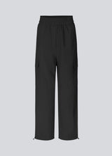 Cargo pants in nylon with elastic waistline and adjustable hems with elastic drawstrings. TrentMD pants have patch pockets on the legs. In black.  This is the same model as our popular pants AmayaMD pants. Just in a thicker material, perfect for fall and winter.