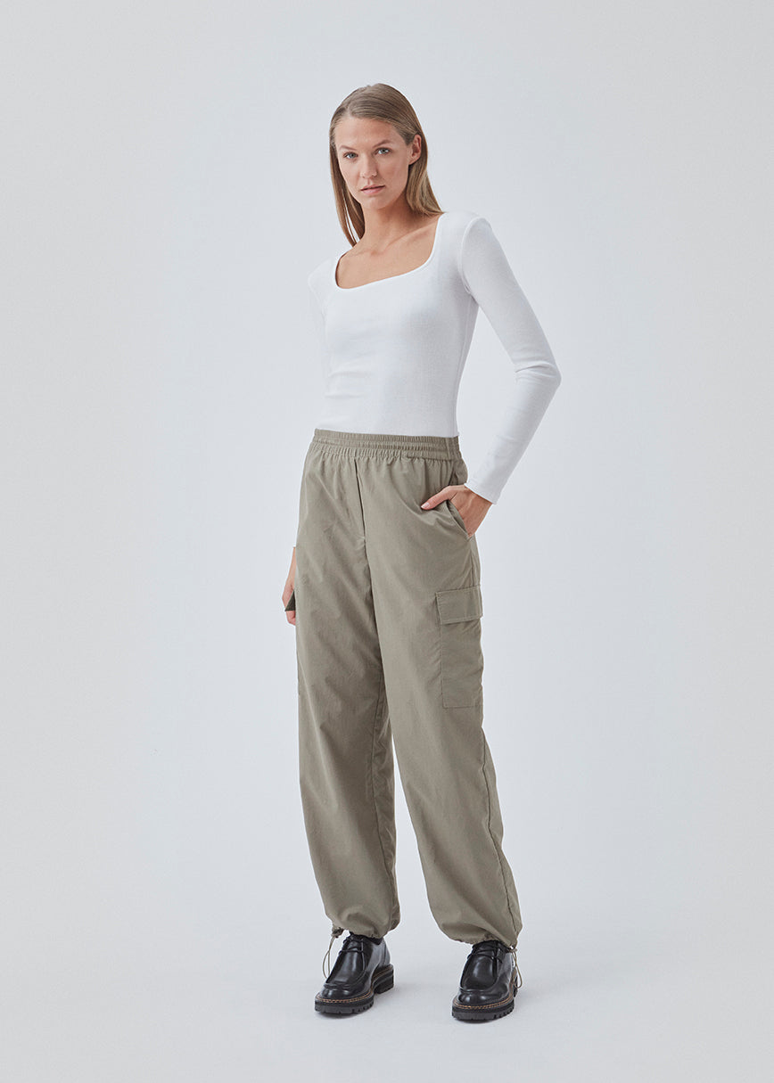 Cargo pants in nylon with elastic waistline and adjustable hems with elastic drawstrings. TrentMD pants have patch pockets on the legs. In Spring Stone.  This is the same model as our popular pants AmayaMD pants. Just in a thicker material, perfect for fall and winter.